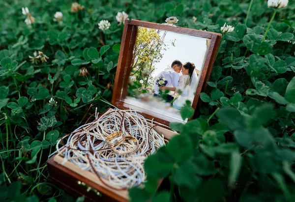 신부와 신랑의 잔디에 반지와 상자의 거울에서의 — 스톡 사진