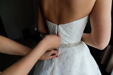 Gelin gelinlik içinde. Nedime tutuşun korse gelinin arkasına