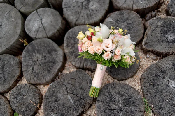 Wedding bouquet of peach roses and white orchids on stumps