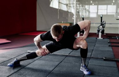 Genç adam eğitim önce kasları hazırlanıyor. Egzersiz kas atlet. Germe adam uygun. Isınma-up profesyonel sporcu
