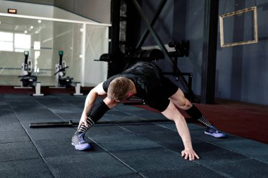 Genç adam eğitim önce kasları hazırlanıyor. Egzersiz kas atlet. Germe adam uygun. Isınma-up profesyonel sporcu