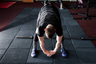 Genç adam eğitim önce kasları hazırlanıyor. Egzersiz kas atlet. Germe adam uygun. Isınma-up profesyonel sporcu