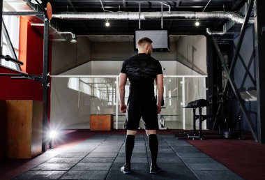 Eğitim, arkadan görünüm önce hazırlanması kasları genç adam. CrossFit egzersiz kas atlet. Egzersiz yaşam tarzı kavramı. Tam vücut uzunluğu portre