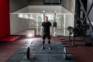 Sakallı adam bir halter salonunda eğitimle hazırlanılıyor