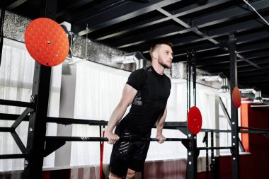 Yatay çubuğu spor salonunda egzersiz genç adam. Erkek yetişkin çalışma dışarı triceps ve pazı crossfit eğitim olarak yatay çubuğu 