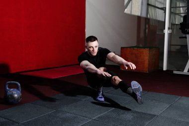 Spor salonunda bir bacak üzerinde tabanca yapan kas sakallı erkek ağız kavgası