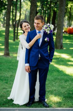 Gelin ve damat hugs parkta. Damat gelini kucaklar. Evlilik çift, düğün günü aşık