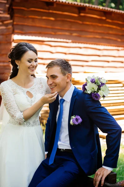 Bela noiva sorridente jovem segurando noivo pelo queixo. Casamento casal apaixonado no dia do casamento — Fotografia de Stock