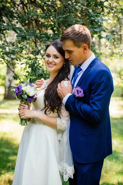 El novio abraza a la novia. Pareja de boda enamorada en el día de la boda —  Fotos de Stock