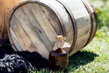 Şişe şarap yakınındaki eski ahşap şarap varil bulanıklık. Düğün süslemeleri açık havada