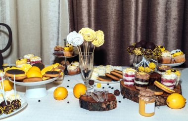 Tatil çikolata kahverengi ve sarı renkte. Çikolata ile cupcakes hizmet düğün, pasta çıkar, gözlük, limon ve kahve çekirdekleri tatlılar 