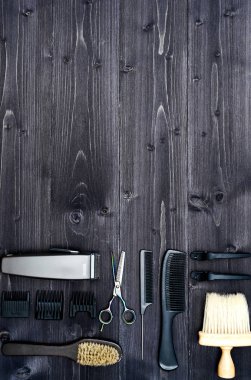 Kuaför araçlar ahşap arka plan üzerinde. Üstten görünüm makas, tarak, fırçaları ve tokalar, boş alan ahşap tablo. Berber dükkanı