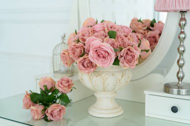 Oval ayna ile beyaz boudoir tabloda vazoda pembe rores buket. Kadın kadının küçük özel odası ile oda iç detay