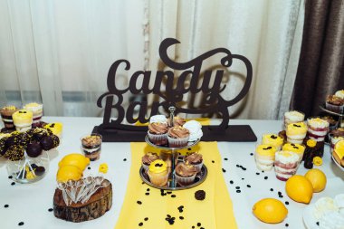 Tatil çikolata kahverengi ve sarı renkte. Çikolata ile cupcakes hizmet düğün, pasta çıkar, gözlük, limon ve kahve çekirdekleri tatlılar 