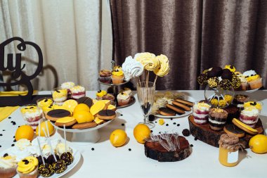 Tatil çikolata kahverengi ve sarı renkte. Çikolata ile cupcakes hizmet düğün, pasta çıkar, gözlük, limon ve kahve çekirdekleri tatlılar 