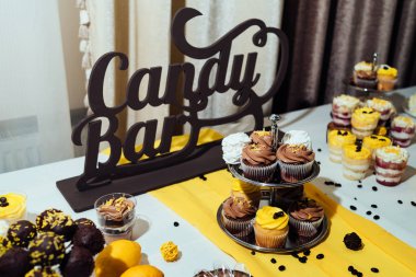 Tatil çikolata kahverengi ve sarı renkte. Çikolata ile cupcakes hizmet düğün, pasta çıkar, gözlük, limon ve kahve çekirdekleri tatlılar 