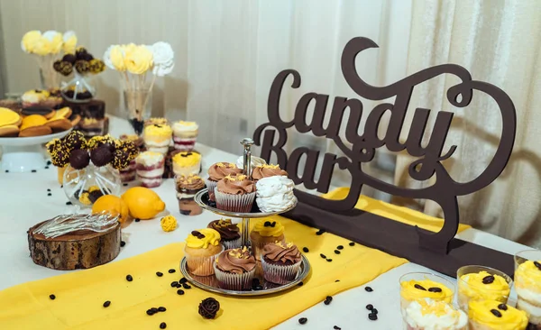 Holiday candy bar. Candy bar served with cupcakes with chocolate and lemon cream on stump and others sweets