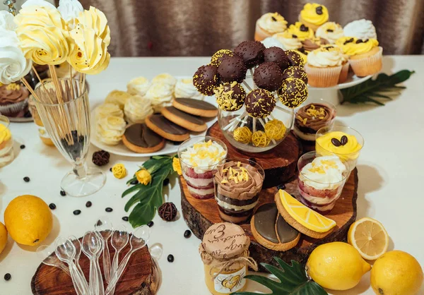 Tatil çikolata kahverengi ve sarı renkte. Çikolata ile cupcakes hizmet düğün, pasta çıkar, gözlük, limon ve kahve çekirdekleri tatlılar 