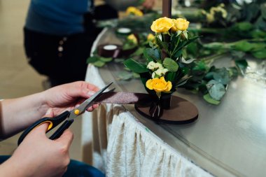 Buket Sarı gül. Kadının elleri kahverengi şerit kesme. Çiçekçinin eller çiçek kompozisyon yapma