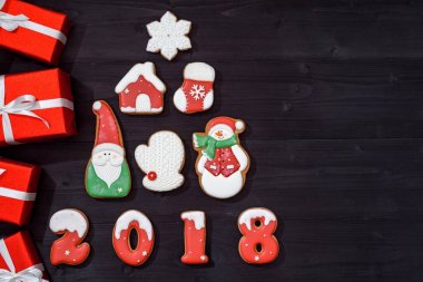 Zencefilli kurabiye ve ahşap zemin, kopya alanı üzerine kırmızı hediyeler yapılan köknar ağacı ile Noel arka plan. Yeni yıl 2018 kartpostal gingerbread kardan adam, Noel Baba, kar tanesi, house, mitten, çorap ile