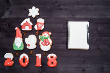 Noel arka plan ile köknar ağacı gingerbread çerezleri ve boş defter kalem ahşap arka plan, kopya alanı ile yapılmış. Yeni yıl 2018 kartpostal 
