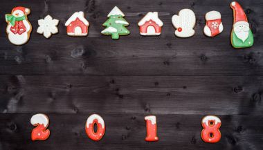 Mutlu yeni yıl 2018 işareti simgesi kopya alanı koyu ahşap arka plan üzerinde kırmızı ve beyaz gingerbread çerezleri üzerinden. Üstten Görünüm, düz yatıyordu. Noel çerezleri sınır, boş alan. Noel arka plan