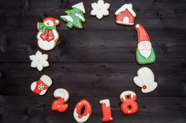 Ahşap masa, kopya alanı, üstten Görünüm Noel lezzetli ev yapımı gingerbread çerezleri çerçevesinden. Yeni yıl 2018 numaraları, düz pişmiş yatıyordu. Noel kurabiyeleri: ağaç, kar tanesi, house, santa, mitten, çorap