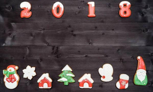 Happy new year 2018 sign symbol from red and white gingerbread cookies on dark wooden background, copy space. Top view, flat lay. Christmas cookies border, free space — Stock Photo, Image
