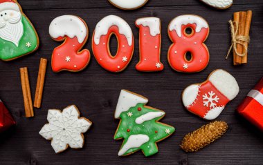 Mutlu yeni yıl 2018 işareti simgesi kırmızı ve beyaz gingerbread çerezleri üzerinde koyu ahşap arka plan, kopya alanı ile. Üstten Görünüm, düz yatıyordu. Noel kurabiyeleri, boş alan