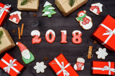 Mutlu yeni yıl 2018 işareti simgesi kırmızı ve beyaz gingerbread çerezleri üzerinde koyu ahşap arka plan, kopya alanı ile. Üstten Görünüm, düz yatıyordu. Noel çerezleri, Noel Baba, kardan adam, kar tanesi, tarçın, boş alan