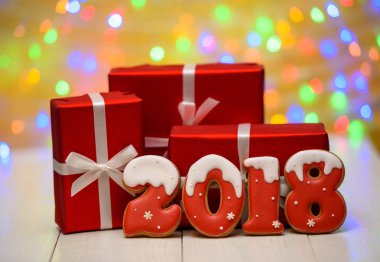 Yeni yıl 2018 gingerbread çerezleri altın arka plan, kopya alanı üzerinde bokeh ve lens flare desenli ile yaptı. Gingerbread çerezleri ve kırmızı hediye kutuları ile yeni yıl 2018 veya Noel Kartpostalı