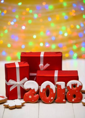 Yeni yıl 2018 gingerbread çerezleri altın arka plan, kopya alanı üzerinde bokeh ve lens flare desenli ile yaptı. Gingerbread çerezleri ve kırmızı hediye kutuları ile yeni yıl 2018 veya Noel Kartpostalı