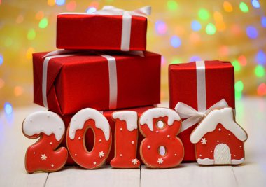 Yeni yıl 2018 gingerbread çerezleri altın arka plan, kopya alanı üzerinde bokeh ve lens flare desenli ile yaptı. Gingerbread çerezleri ve kırmızı hediye kutuları ile yeni yıl 2018 veya Noel Kartpostalı