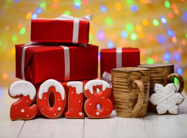 Yeni yıl 2018 gingerbread çerezleri altın arka plan, kopya alanı üzerinde bokeh ve lens flare desenli ile yaptı. Noel artalanla gingerbread çerezleri, fincan kakao ve kırmızı hediye kutuları 