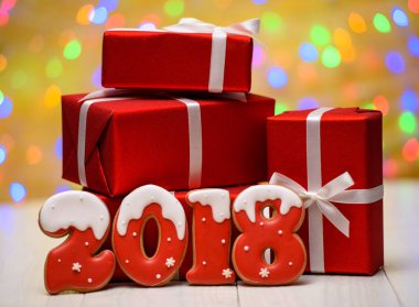 Yeni yıl 2018 gingerbread çerezleri altın arka plan, kopya alanı üzerinde bokeh ve lens flare desenli ile yaptı. Gingerbread çerezleri ve kırmızı hediye kutuları ile yeni yıl 2018 veya Noel arka plan