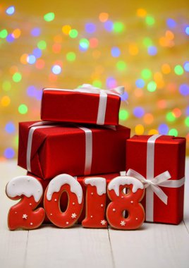 Yeni yıl 2018 gingerbread çerezleri altın arka plan, kopya alanı üzerinde bokeh ve lens flare desenli ile yaptı. Gingerbread çerezleri ve kırmızı hediye kutuları ile yeni yıl 2018 veya Noel arka plan