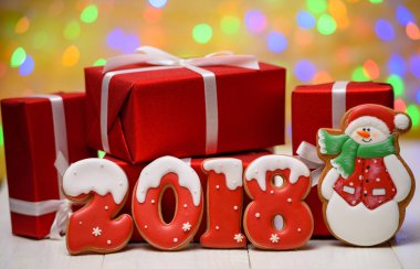 Yeni yıl 2018 gingerbread çerezleri altın arka plan, kopya alanı üzerinde bokeh ve lens flare desenli ile yaptı. Gingerbread çerezleri ve kırmızı hediye kutuları ile yeni yıl 2018 veya Noel Kartpostalı