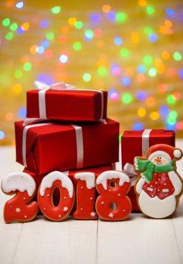 Yeni yıl 2018 gingerbread çerezleri altın arka plan, kopya alanı üzerinde bokeh ve lens flare desenli ile yaptı. Gingerbread çerezleri ve kırmızı hediye kutuları ile yeni yıl 2018 veya Noel Kartpostalı