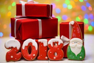 Yeni yıl 2018 işareti simgesi gingerbread çerezleri, Noel Baba ve kırmızı hediye altın arka plan, kopya alanı üzerinde bokeh ve lens flare desenli kutular