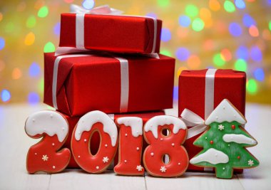 Yeni yıl 2018 gingerbread çerezleri altın arka plan, kopya alanı üzerinde bokeh ve lens flare desenli ile yaptı. Gingerbread çerezleri ve kırmızı hediye kutuları ile yeni yıl 2018 veya Noel Kartpostalı