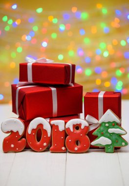 Yeni yıl 2018 işareti simgesi, Noel ağacı gingerbread çerezleri ve altın arka plan, kopya alanı üzerinde bokeh ve lens flare desenli kırmızı hediye kutuları ile yaptı