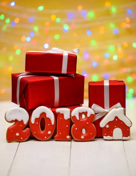 Yeni yıl 2018 gingerbread çerezleri altın arka plan, kopya alanı üzerinde bokeh ve lens flare desenli ile yaptı. Gingerbread çerezleri ve kırmızı hediye kutuları ile yeni yıl 2018 veya Noel Kartpostalı