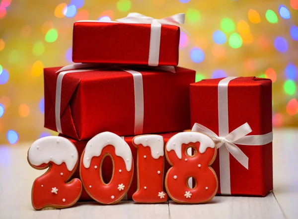 Yeni yıl 2018 gingerbread çerezleri altın arka plan, kopya alanı üzerinde bokeh ve lens flare desenli ile yaptı. Gingerbread çerezleri ve kırmızı hediye kutuları ile yeni yıl 2018 veya Noel arka plan