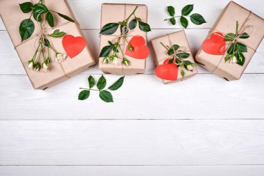 Hediye kutuları taze gül ve ahşap masa, kopya alanı üzerinde kırmızı kalpler. Tatil arka plan, satış, alışveriş. Hediye. Tebrik kartı Womans gün, Sevgililer günü, anneler günü, düz için yatıyordu. Aşk 