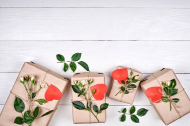 Hediye kutuları taze gül ve ahşap masa, kopya alanı üzerinde kırmızı kalpler. Tatil arka plan, satış, alışveriş. Hediye. Tebrik kartı Womans gün, Sevgililer günü, anneler günü, düz için yatıyordu. Aşk 