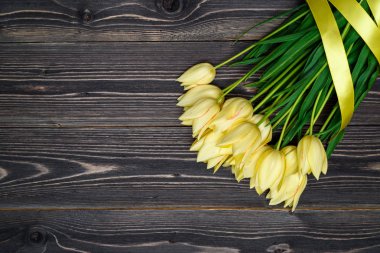 Lale ile kurdele, kopya alanı Grup ile bahar arka plan. Ahşap zemin üzerine sarı laleler. Düz yatıyordu, en iyi görünüm. Sevgililer günü, Woman's Day, anneler günü, Paskalya için tatil tebrik kartı