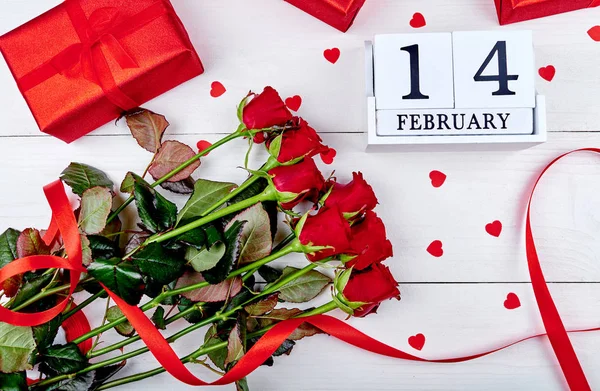 バレンタインデーの背景に赤いバラ ギフト ボックス リボン 木製のブロック カレンダーの 日の束は 領域をコピーします グリーティング カードのモックアップ — ストック写真