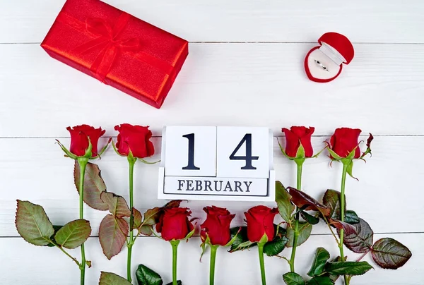 Piros rózsák, díszdobozban, a gyémánt gyűrű és a fából készült blokk naptár február 14, Valentin-nap háttér másolja a hely. Üdvözlőlap makett. Szeretet fogalma. Felülnézet. Lapos feküdt — Stock Fotó