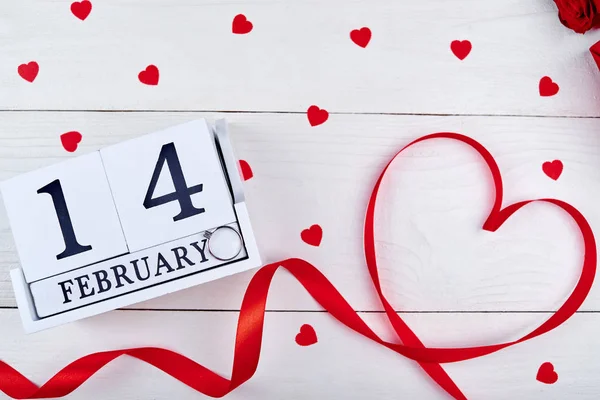 Valentines Day background with ribbon shaped as heart and diamond ring on wooden block calendar february 14, copy space. Greeting card mockup. Love concept. Top view. Flat lay — Stock Photo, Image