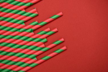 Kırmızı arkaplanda kırmızı ve yeşil çizgili pipetler, boşluğu kopyala